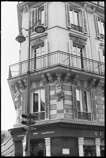 Angle de deux façades ornée de deux cariatides en gaine avec bras