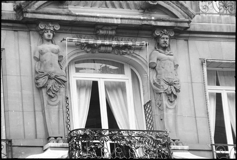 Façade ornée d'un atlante et d'une cariatide en gaine sans bras : vue rapprochée
