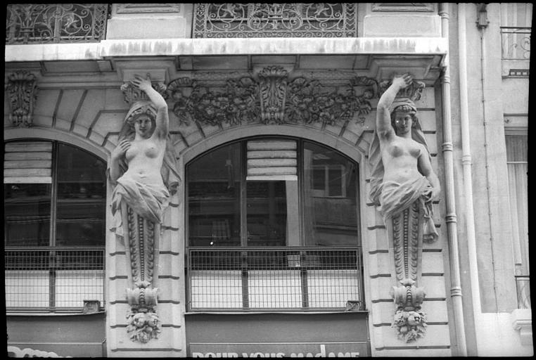 Façade ornée de deux cariatides en gaine avec bras : vue rapprochée