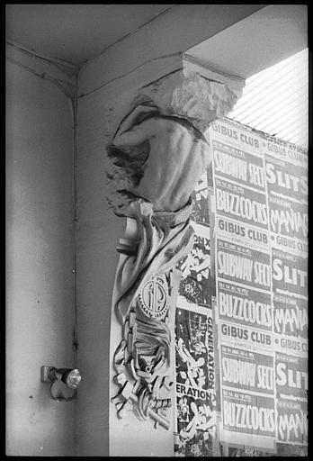 Entrée ornée d'atlantes en gaine avec bras : vue rapprochée d'un atlante