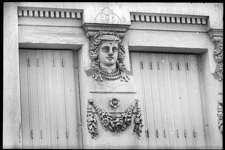 Façade ornée de deux cariatides en buste : vue rapprochée de la cariatide de gauche
