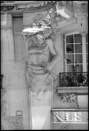 Façade ornée d'atlantes en gaine avec bras : vue rapprochée d'un atlante