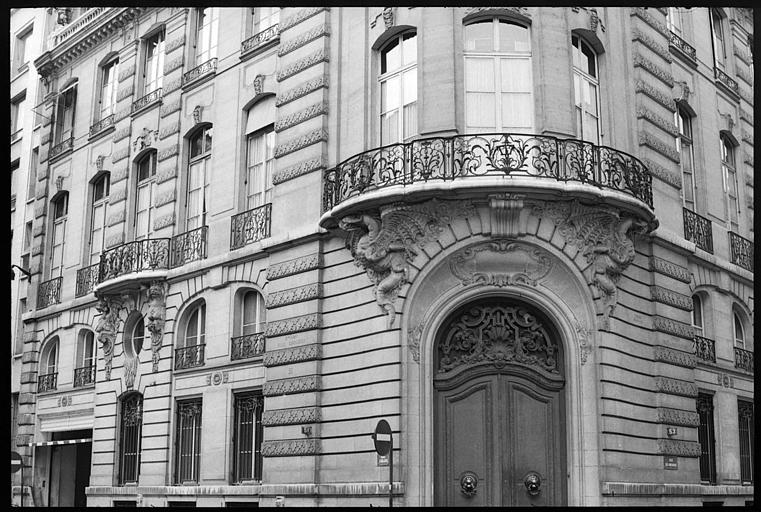 Porche à l'angle de deux façades surmonté de deux dragons atlantes