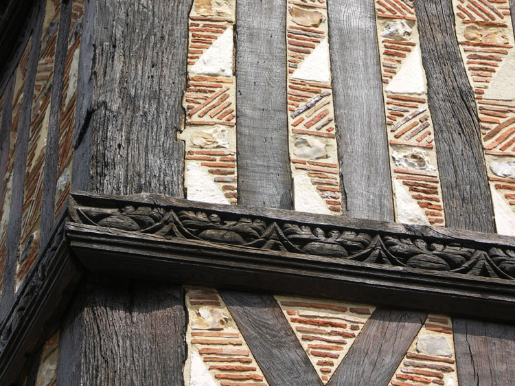 Façade : détail de la lisse sculptée ; pan de bois