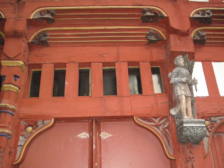 Façade sur rue : dessus de porte et statuette d'un archer