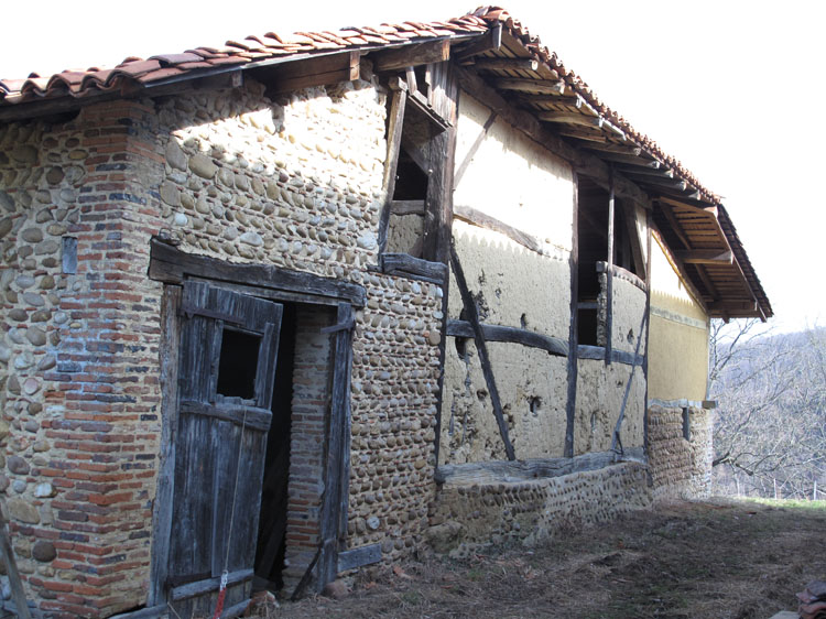 Façade en galets et pans de bois