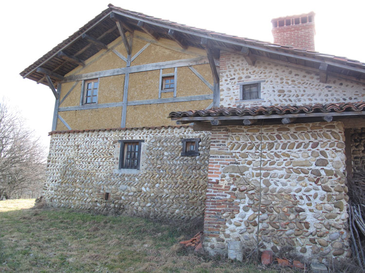 Façade en galets et pans de bois