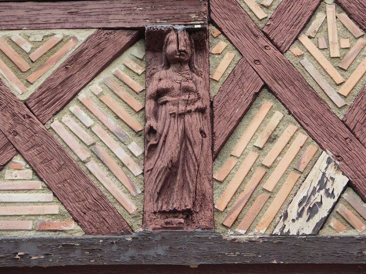 Façade sur la place : figure sculptée et appareil du mur