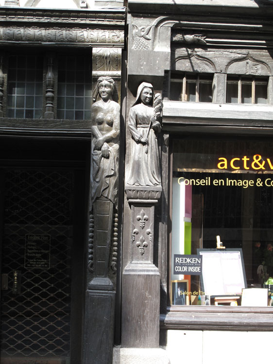 Façade sur rue : poteaux corniers entre les deux maisons avec figures sculptées