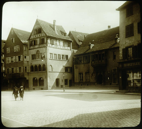 Façade sur la place, vue éloignée, personnages