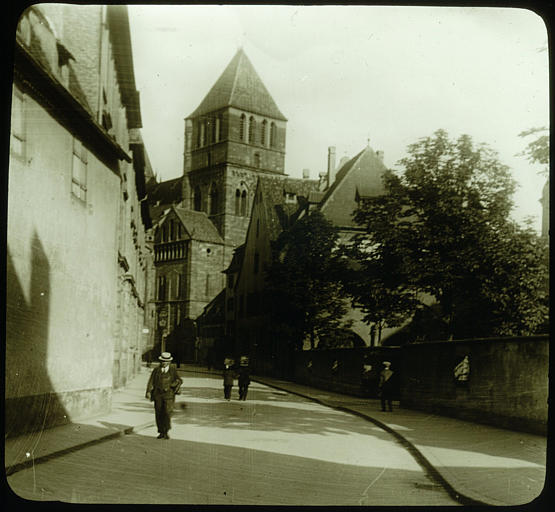 Rue, église à l'arrière-plan, personnages