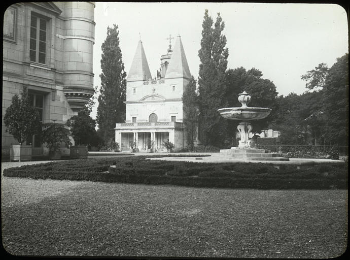 Vue d'ensemble : jardin, parterre, vasque, édifice visible en partie à gauche, chapelle à l'arrière-plan