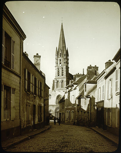 Rue, église à l'arrière-plan, personnages