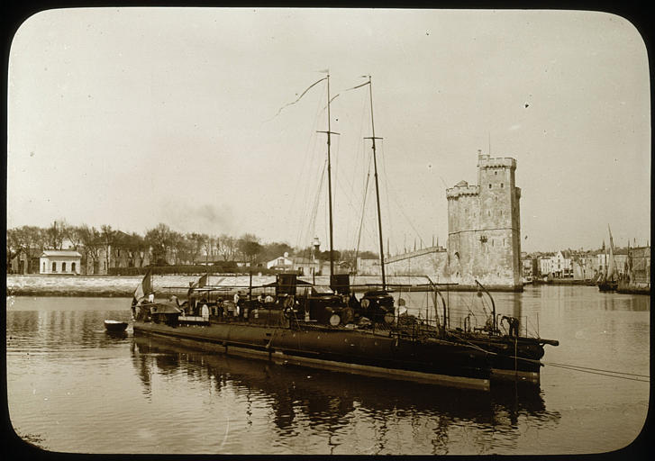 Torpilleurs devant le port de la Rochelle : ensemble du navire par bâbord avant, tour Saint-Nicolas à l'arrière-plan