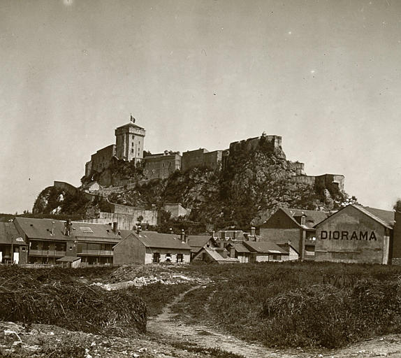 Vue d'ensemble du château et de son emprise rocheuse, maisons en contrebas