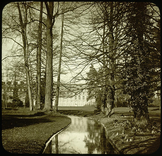 Château vu du parc avec allée d'eau en premier plan