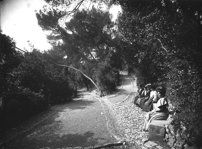 Vue d'une allée. Femmes sur un banc