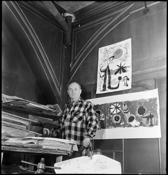 [Portrait de Joan Miró assis dans son atelier entouré de ses lithographies]