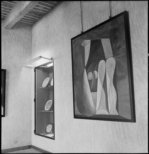 [Salle d'exposition avec vitrine de céramiques et 'Nu assis sur fond vert' de Pablo Picasso]