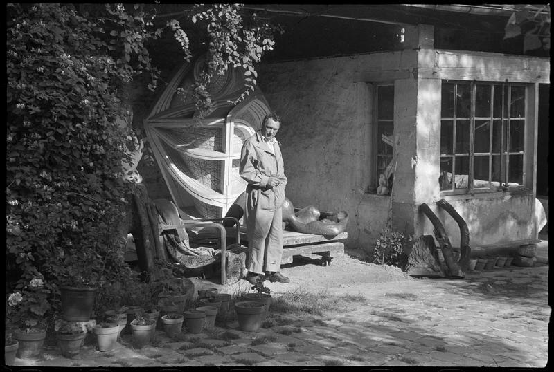 [Portrait de Henri-Georges Adam dans la cour de son atelier à côté de ses oeuvres]