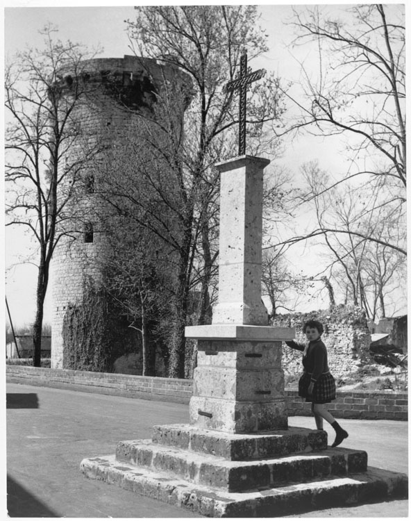 Petite fille à côté d'un calvaire ; Donjon en arrière plan