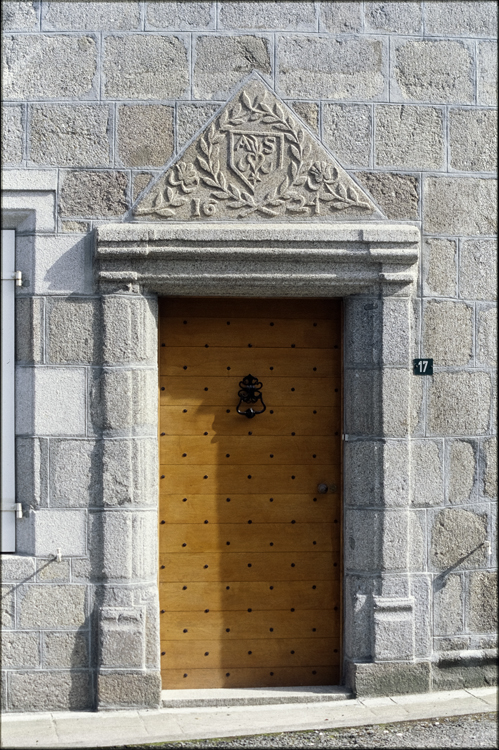 Porte à fronton supportant des armoiries
