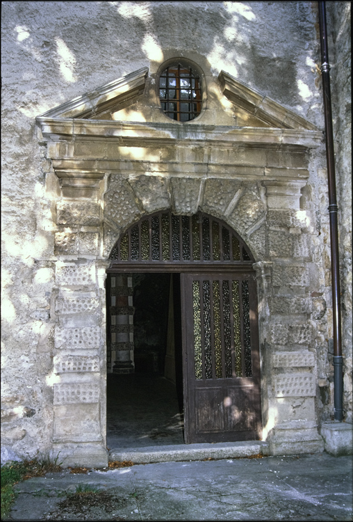 Porte à bosselage et fronton brisé