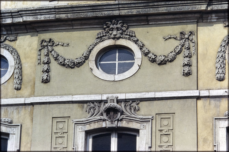 Oeil de boeuf entouré d’un décor en relief avec tête de lion