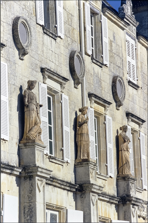 Statues supportées par des pilastres sur façade corps de logis