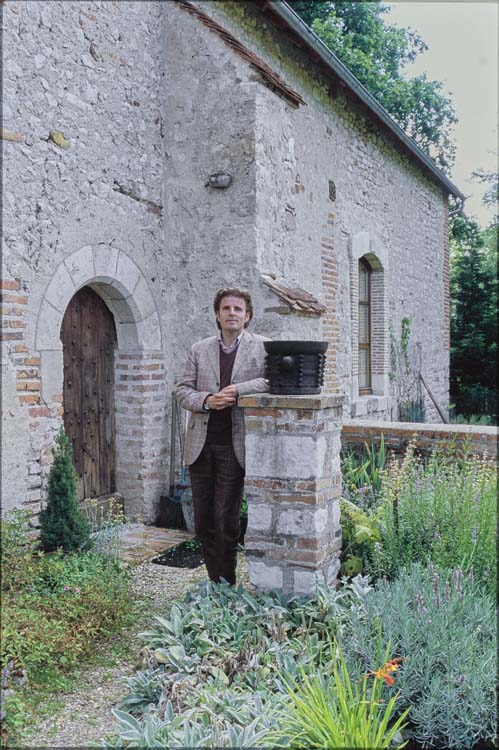 Portrait du propriétaire Olivier de Charsonville devant les communs