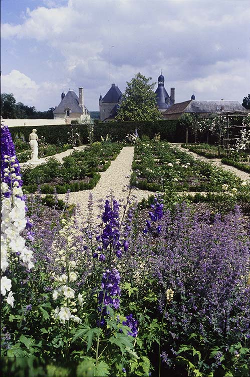 Jardin : parterre de fleurs ; Façade ouest du château à l’arrière-plan