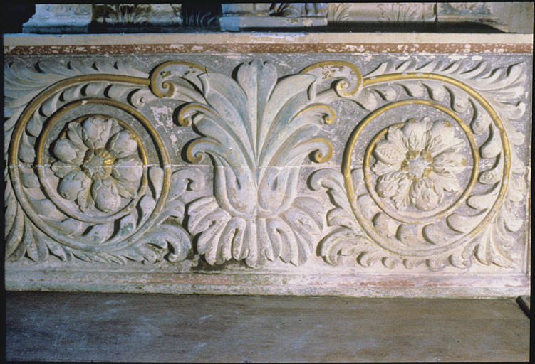 Autel latéral nord ; antependium : bois sculpté, peint, grosse feuille d'acanthe centrale, 2 rinceaux végétaux terminés chacun par une fleur ; 1705 (détail)