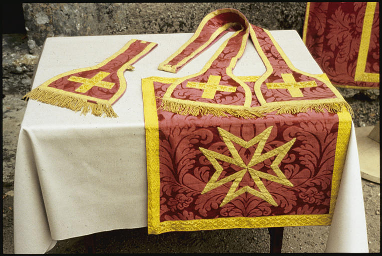 Etole, manipule, voile de calice : tissu damassé rouge à motif de grosses feuilles, galons  jaunes, croix de Malte