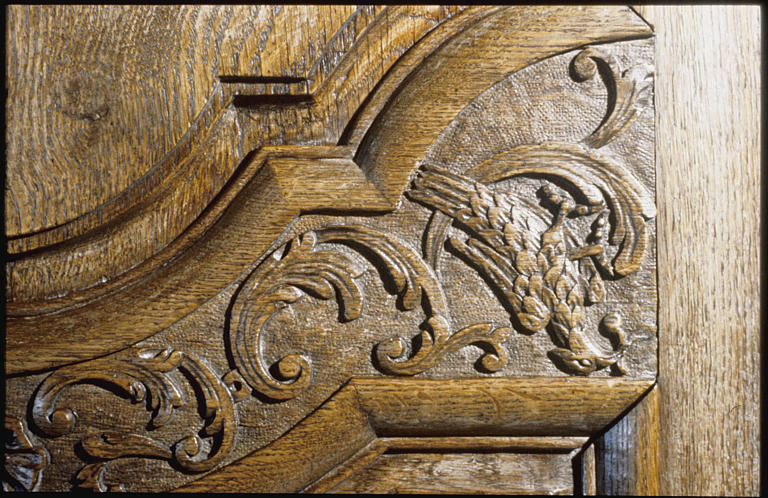 Armoire : vantaux (2), détail motif sculpté, oiseau tenant un fruit dans son bec, rinceaux végétaux (détail)