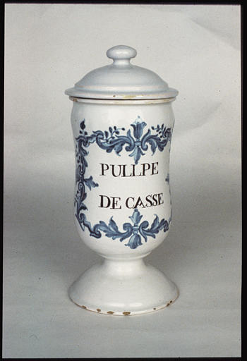 Pot à pharmacie : pot à canon, couvercle, faïence d'Argonne, fond émaillé blanc, décor de rinceaux feuillagés bleu, 'Pulpe de Casse'