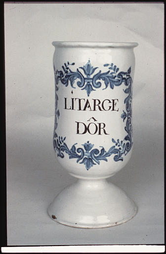 Pot à pharmacie : pot à canon, faïence d'Argonne, fond émaillé blanc, décor de rinceaux feuillagés bleu, 'Litarge Dôrl'