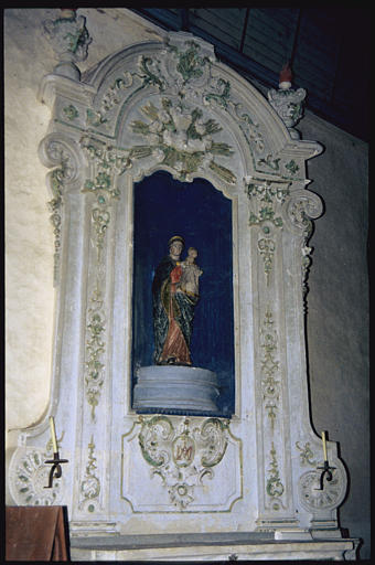 Choeur, autel latéral nord ; retable, groupe sculpté : 'Vierge à l'Enfant', retable architecturé à pilastres soutenant une corniche à fronton cintré, colombe du Saint-Esprit en bas-relief, rinceaux végétaux, pots à feu