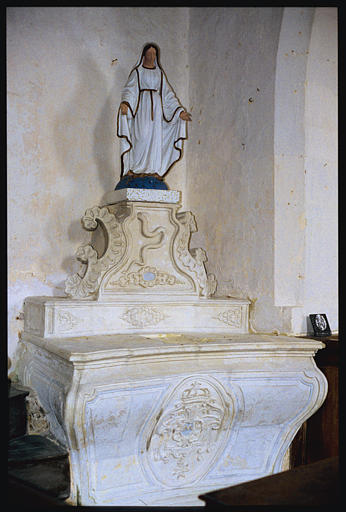 Autel latéral nord ; autel, statue : 'Vierge de l'Immaculée Conception', autel de forme galbée à gros médaillon central en bas-relief sur l'antependium, gradin formant un sorte de socle pour la statue orné de volutes et d'un serpent