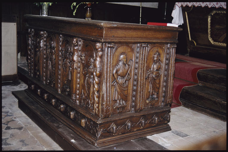 Coffre : bois sculpté, saint Pierre, saint Paul, chacun sous un arc de plein cintre, séparation par des moulures à motifs de feuilles et terminées par un enroulement dans leur partie supérieure (trois quart, vue petit côté)