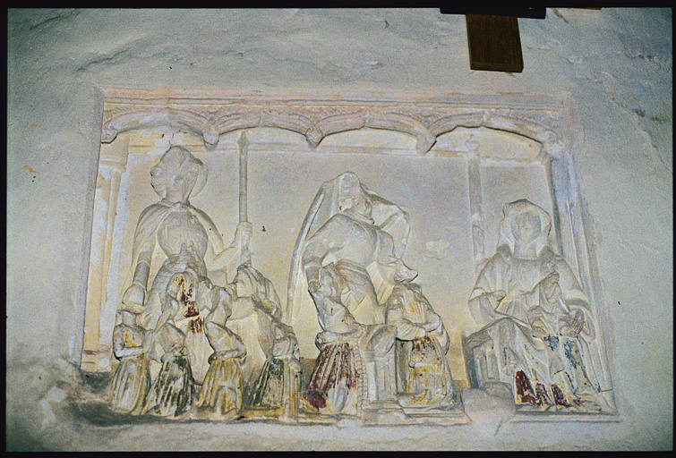 Bas-relief : 'Saint Michel et la Vierge', personnage en armure avec lance, ange, Vierge à l'Enfant assise, six personnages plus petits en orants, visages martelés