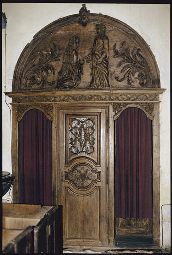 Confessionnal : bois, surmonté d'un fronton cintré décoré d'un bas-relief représentant la Madeleine, agenouillée aux pieds du Christ et tenant un vase à parfum, palmes, porte centrale ajourée de volutes