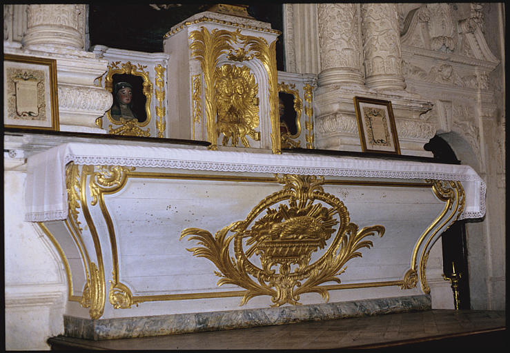 Choeur ; autel, tabernacle : autel galbé sculpté d'un médaillon central avec l'agneau pascal couché sur le livre aux sept sceaux, palmettes, en bas-relief