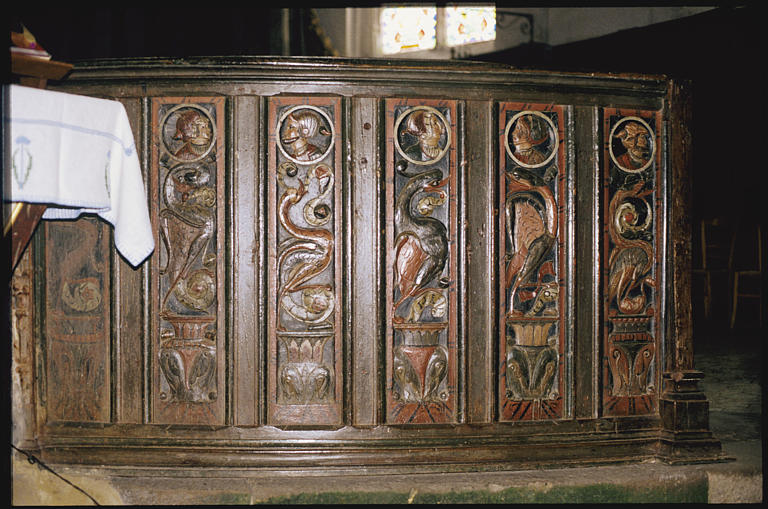 Choeur ; clôture de choeur, clôture courbe, 10 panneaux de bois sculpté en bas-relief d'oiseaux, de vases et de têtes de personnages, de profil, dans des médaillons (détail)