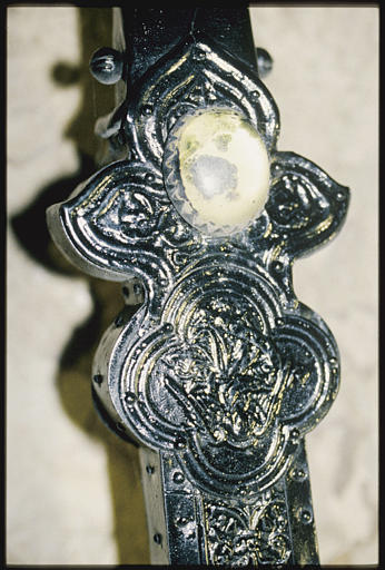 Croix de procession : placage d'argent sur âme de bois, détail d'une branche pattée, agrémentée d'une pierre ovale, jaune pâle, et d'un médaillon quadrilobé au centre duquel est représenté l'ange de saint Matthieu