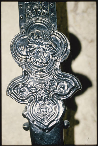 Croix de procession : placage d'argent sur âme de bois, détail d'une branche pattée, agrémentée d'une pierre ovale, jaune pâle, et d'un médaillon quadrilobé au centre duquel est représenté l'ange de saint Matthieu