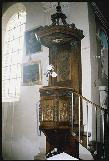 Chaire à prêcher : garde-corps composé de cinq panneaux sculpté en bas-relief, les quatre évangélistes, le Christ prêchant (panneau central), le dorsal présente décor de trophée et de chutes de fruits, l'abat-voix une colombe