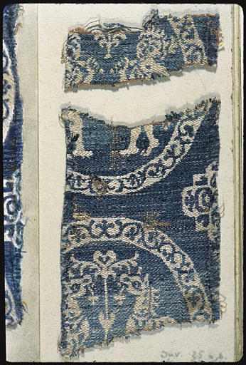 Tissu : 2 fragments, motifs blancs sur fond bleu, deux personnages affrontés et deux chevaux affrontés, dans des médaillons circulaires ornés de rinceaux bleus - © Ministère de la Culture (France), Médiathèque du patrimoine et de la photographie, diffusion RMN-GP