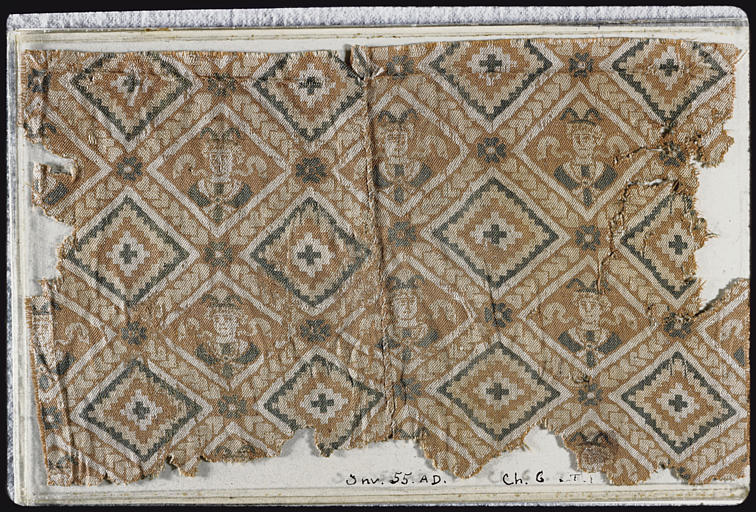 Tissu : fragment, motifs de losanges, certains avec une croix en leur centre, d'autres avec un visage de personnage, lignes formées par des coeurs, fleurettes - © Ministère de la Culture (France), Médiathèque du patrimoine et de la photographie, diffusion RMN-GP