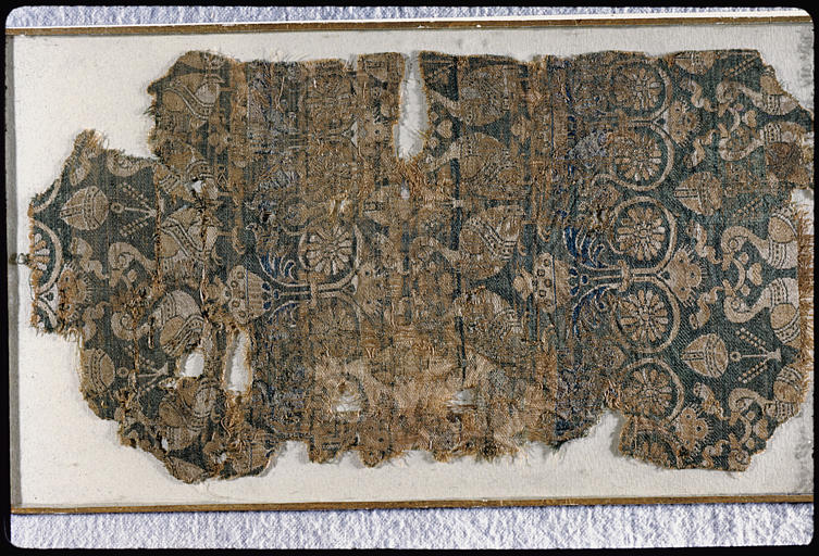 Tissu : fragment, oiseaux affrontés tenant dans leurs becs un ruban, rinceaux  végétaux, motifs blancs et bruns sur fond bleu - © Ministère de la Culture (France), Médiathèque du patrimoine et de la photographie, diffusion RMN-GP