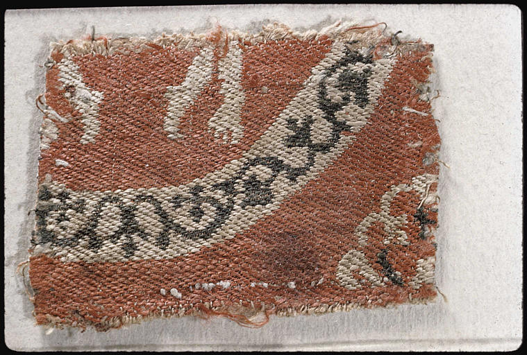 Tissu : fragment, pieds de personnages, médaillon circulaire, blanc sur fond rouge (motif lacunaire) - © Ministère de la Culture (France), Médiathèque du patrimoine et de la photographie, diffusion RMN-GP